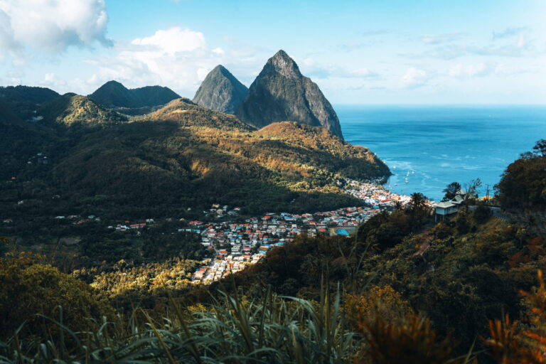 Soufriere, St Lucia from an overlook with the world famous Pitons in the background and beautiful blue Caribbean waters and a partly cloudy day.